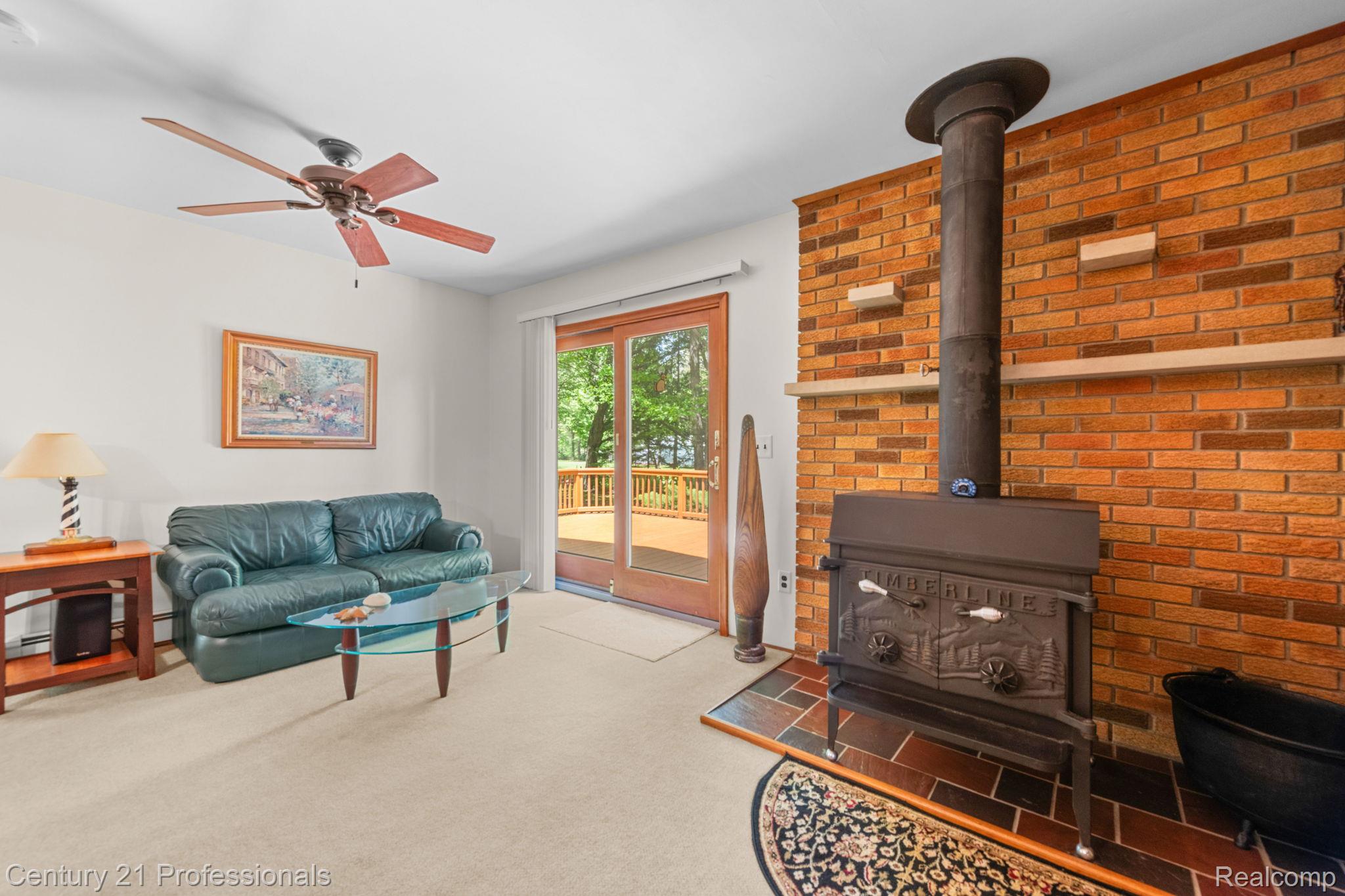 8638 Stone Road Algonac, MI 48001 - Photo 38 of 70 Living area featuring carpet flooring and a wood stove
