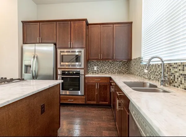 a kitchen with kitchen island granite countertop a sink stove and refrigerator