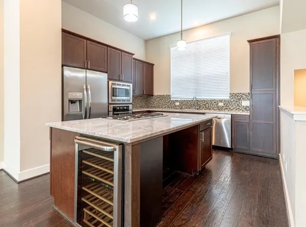 a kitchen with stainless steel appliances granite countertop a stove a refrigerator and a sink