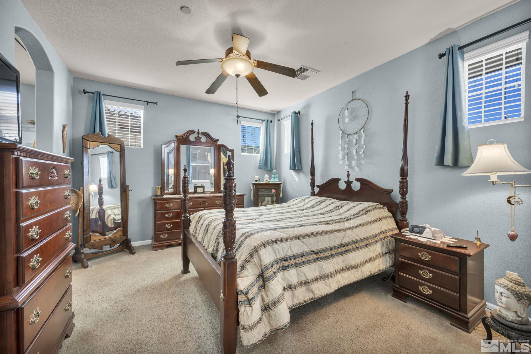 1924 Wind Ranch Road, Unit C Reno, NV 89521 - Photo 18 of 27 a bed room with a bed and a chandelier