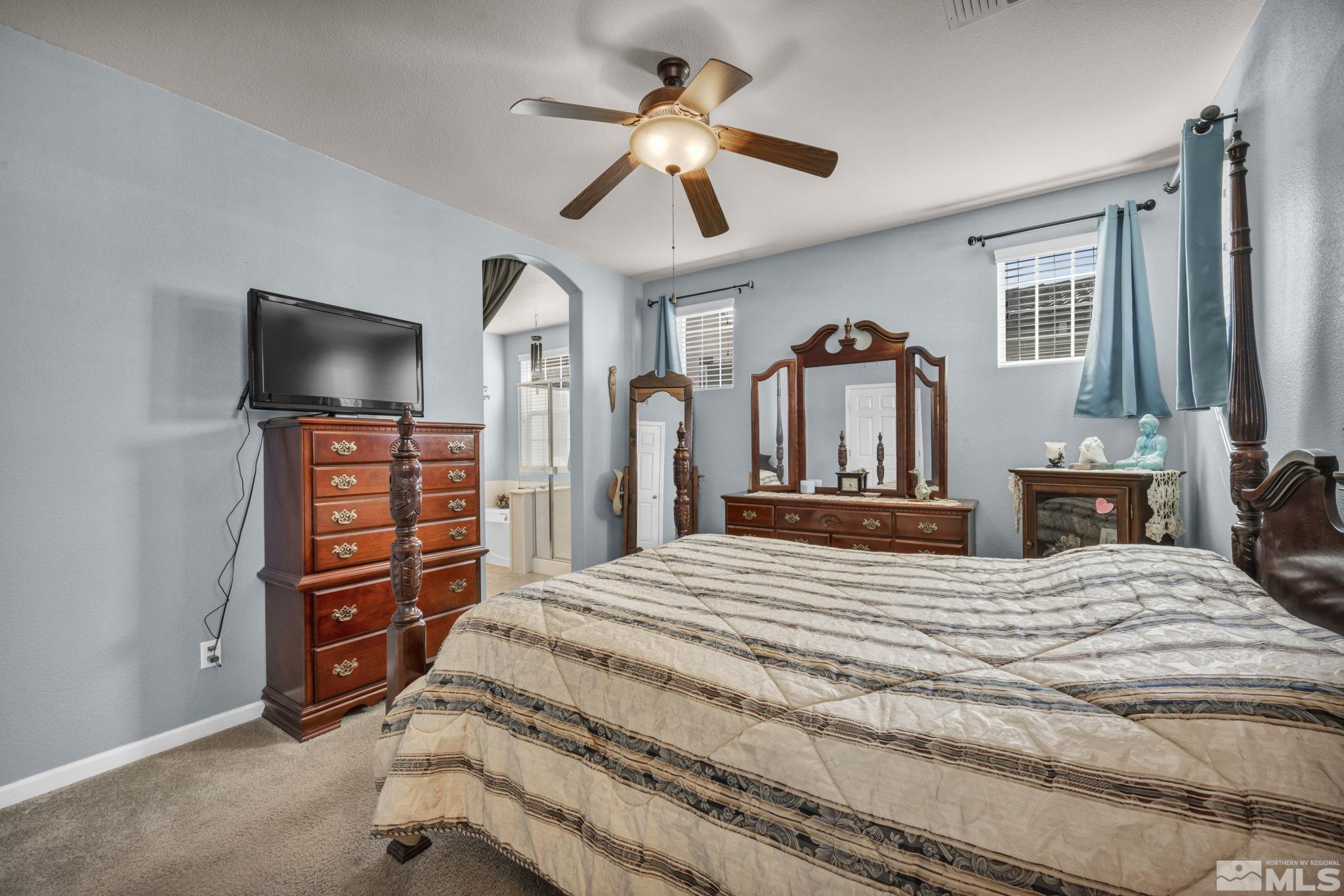 1924 Wind Ranch Road, Unit C Reno, NV 89521 - Photo 19 of 27 a bedroom with a bed and a chandelier