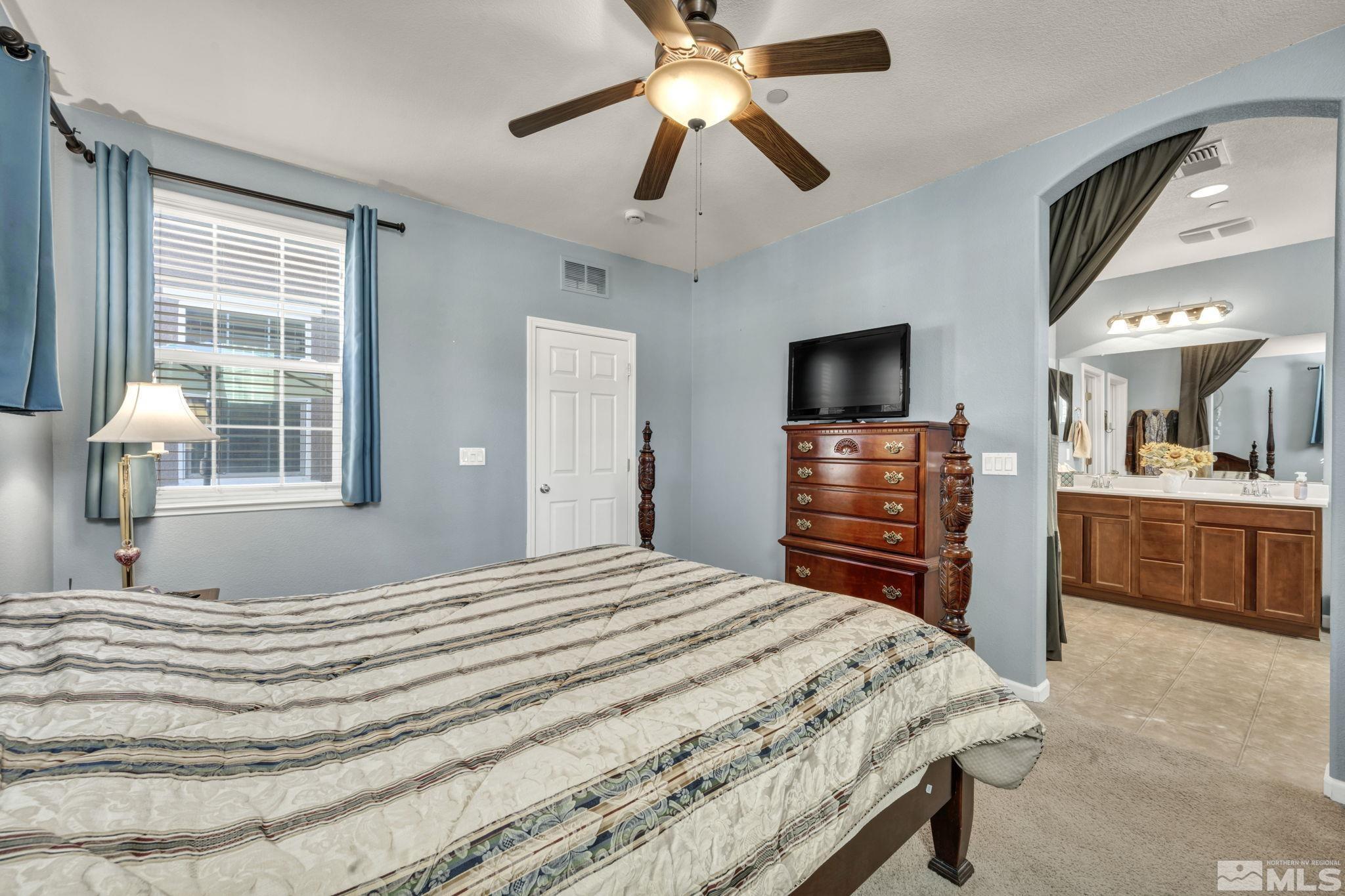 1924 Wind Ranch Road, Unit C Reno, NV 89521 - Photo 20 of 27 a bedroom with a bed and a flat tv screen on dresser