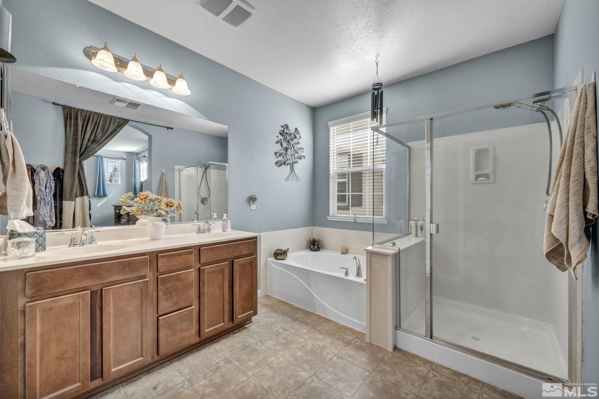 1924 Wind Ranch Road, Unit C Reno, NV 89521 - Photo 21 of 27 a bathroom with a tub a sink shower and mirror