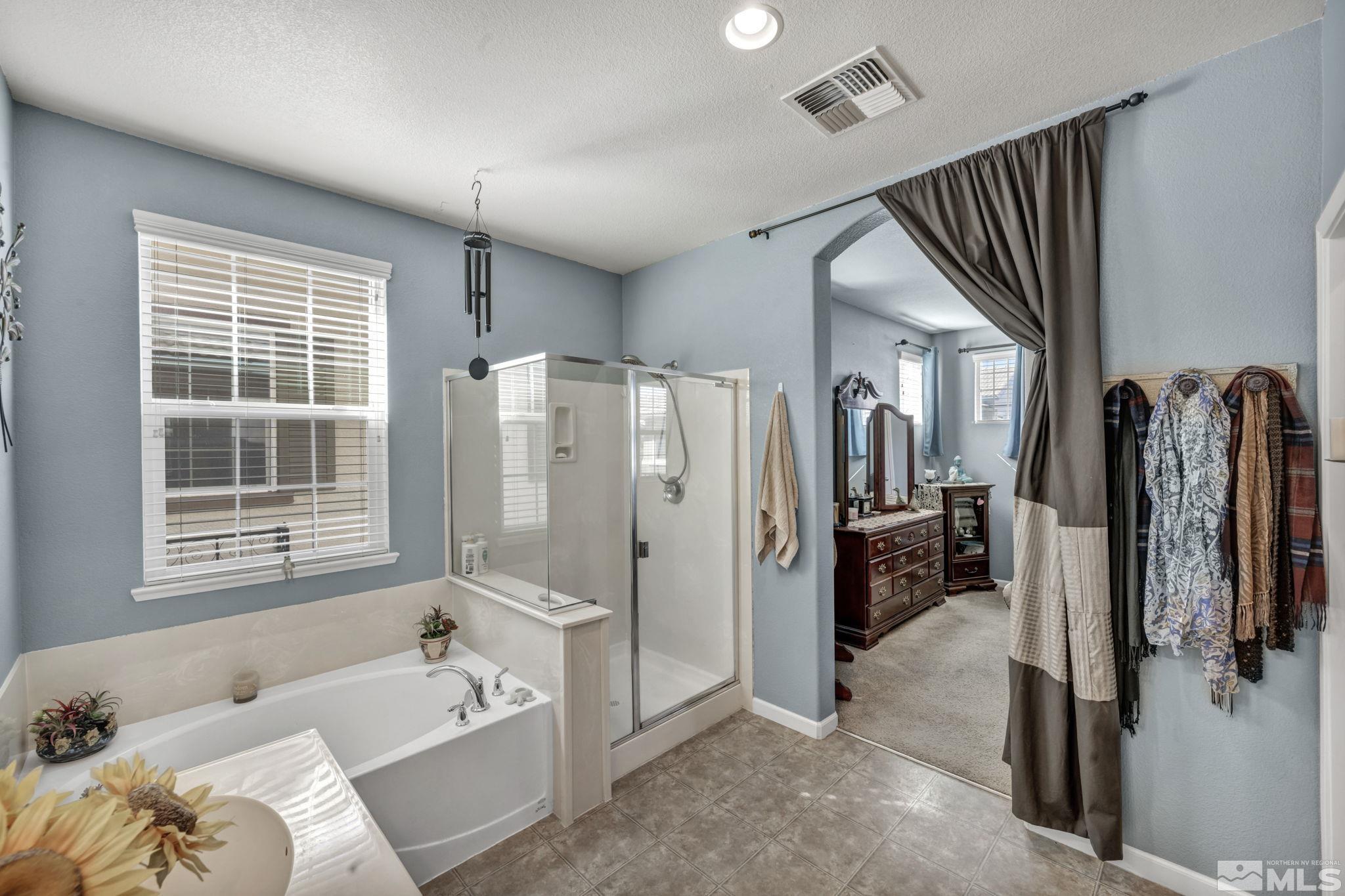 1924 Wind Ranch Road, Unit C Reno, NV 89521 - Photo 22 of 27 a spacious bathroom with a tub sink and mirror