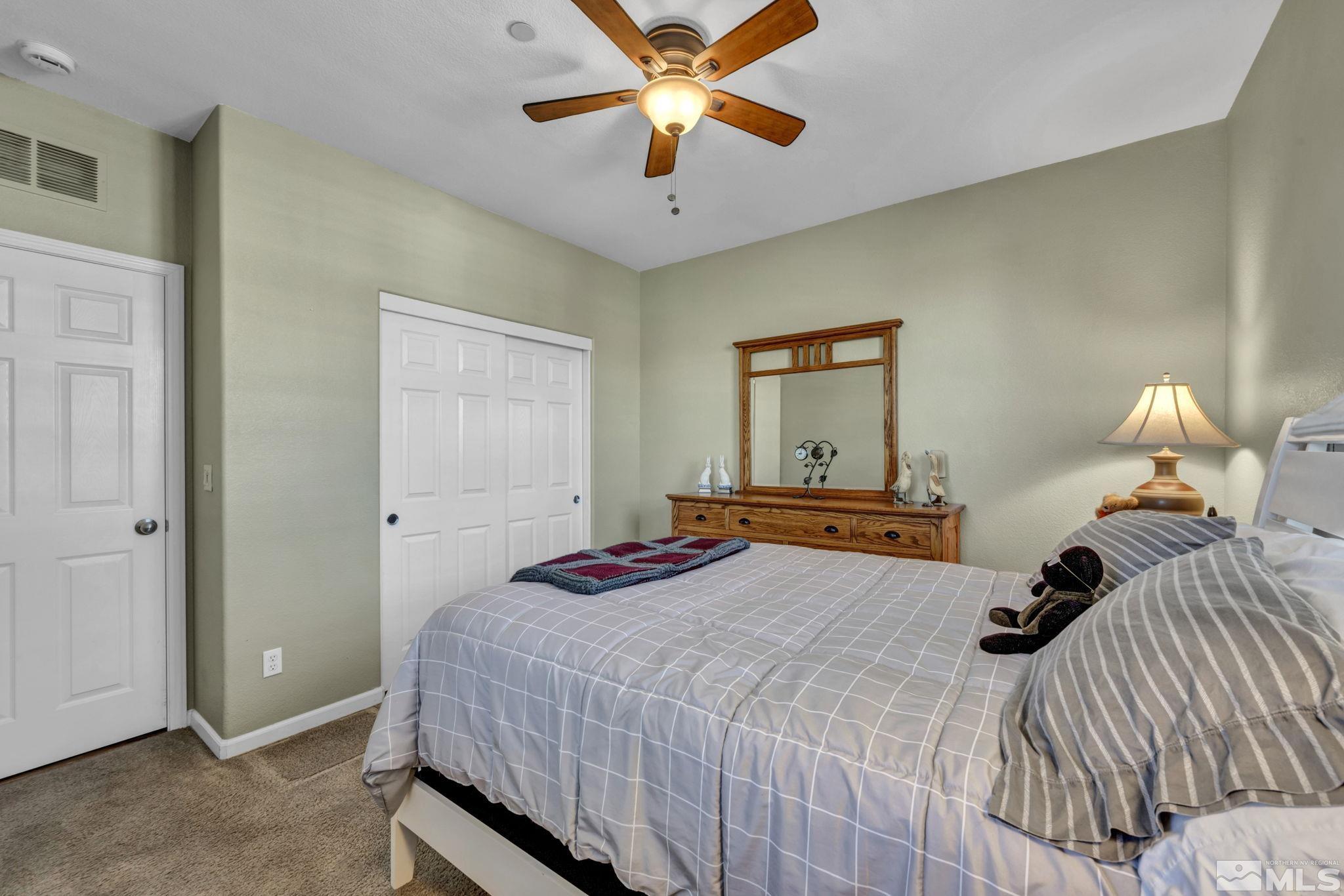 1924 Wind Ranch Road, Unit C Reno, NV 89521 - Photo 25 of 27 a bedroom with a bed and a chandelier