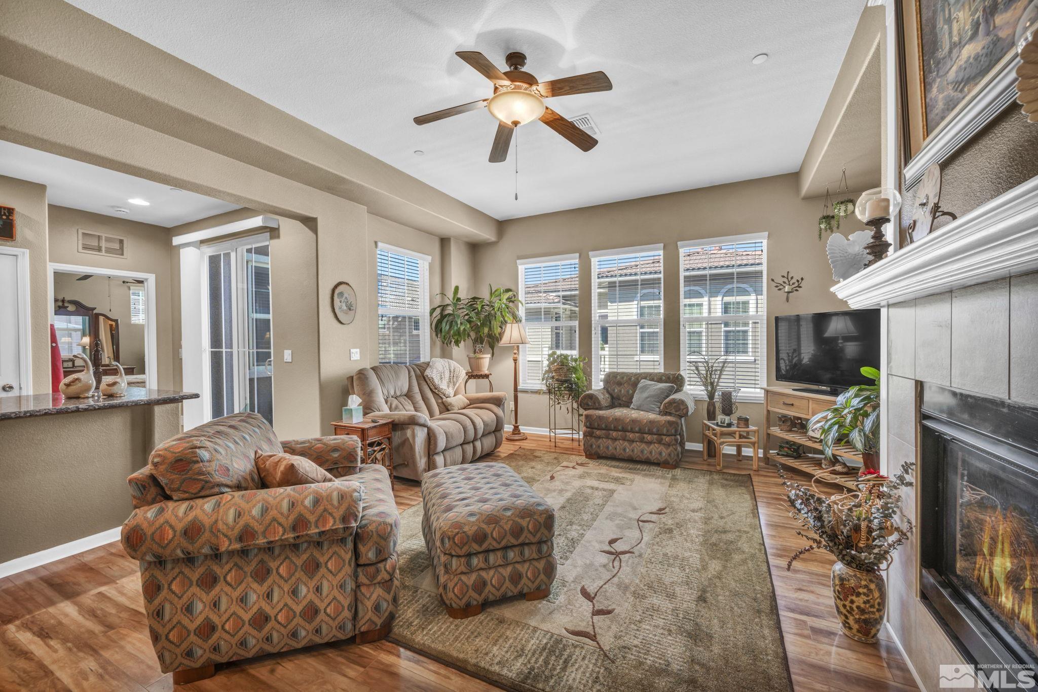 1924 Wind Ranch Road, Unit C Reno, NV 89521 - Photo 8 of 27 a living room with furniture ceiling fan and a fireplace