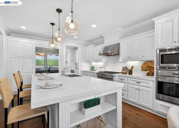 a kitchen with a stove a white table and chairs in it