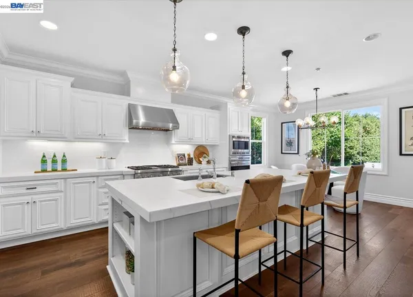 a kitchen with a dining table chairs sink and cabinets