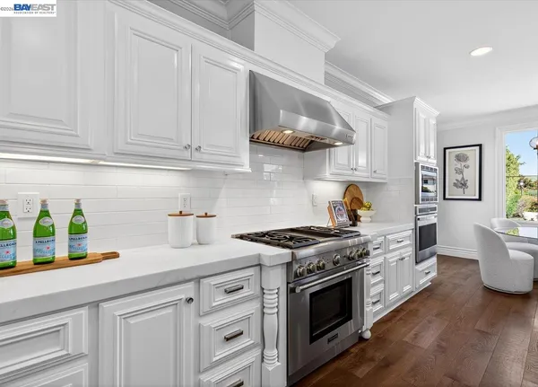 a kitchen with stainless steel appliances granite countertop a stove and a white cabinets