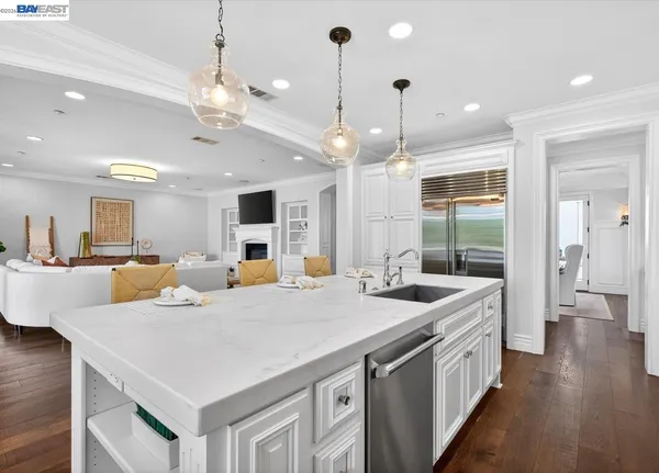 a large kitchen with kitchen island a stove a sink a center island and living room view