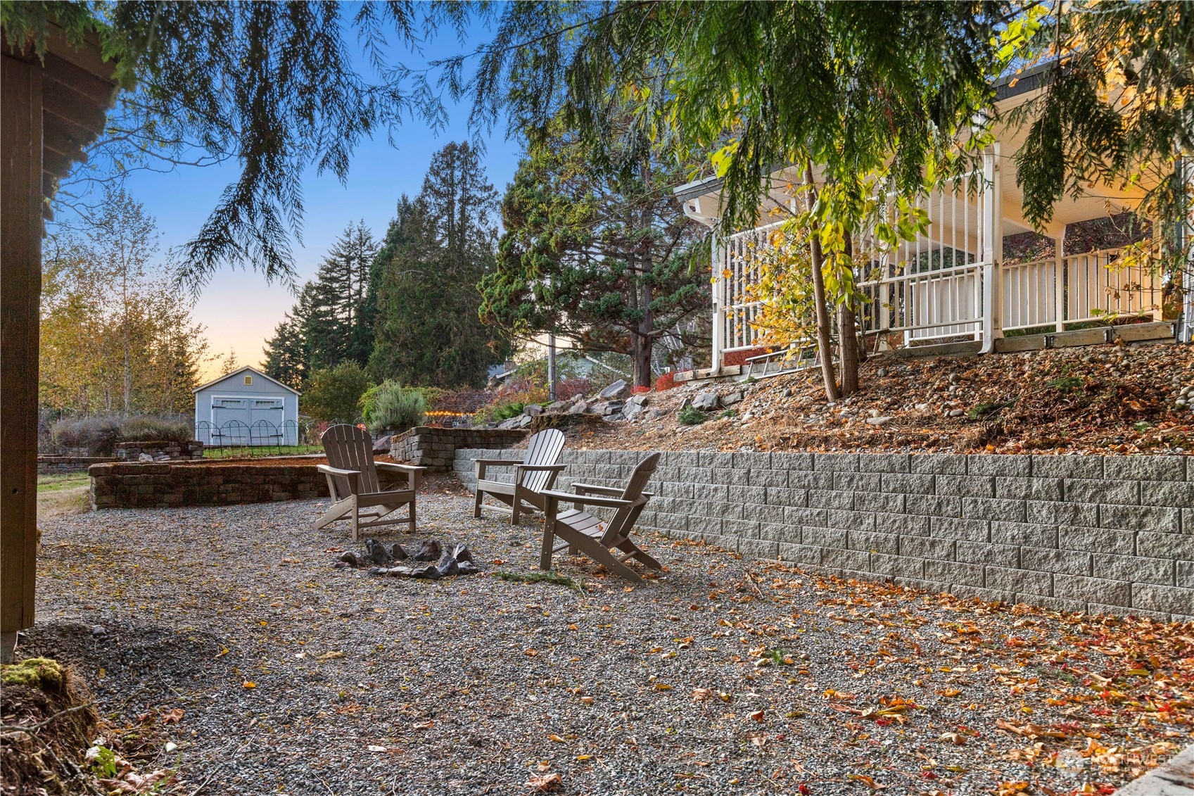 11030 Circle Drive Bothell, WA 98011 - Photo 33 of 38 a view of a backyard with table and chairs with a fire pit and a large tree