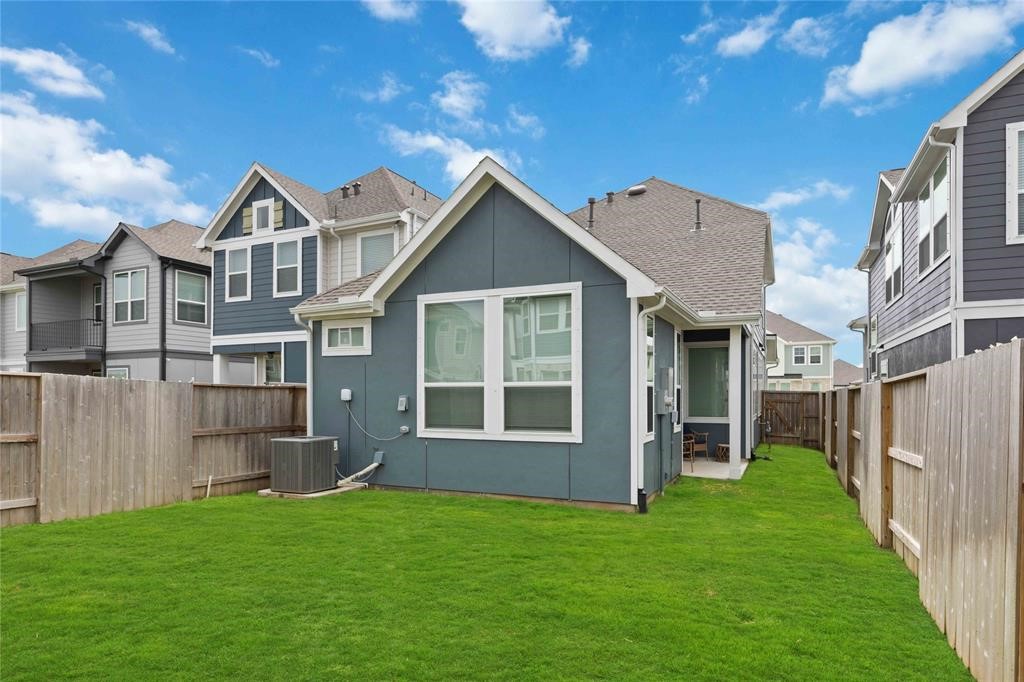 10014 Nectar Path Iowa Colony, TX 77583 - Photo 25 of 26 Charming two-story home with a well-maintained backyard, featuring a lush lawn and privacy fencing. The exterior is modern, with large windows providing ample natural light. Ideal for families seeking a cozy outdoor space.