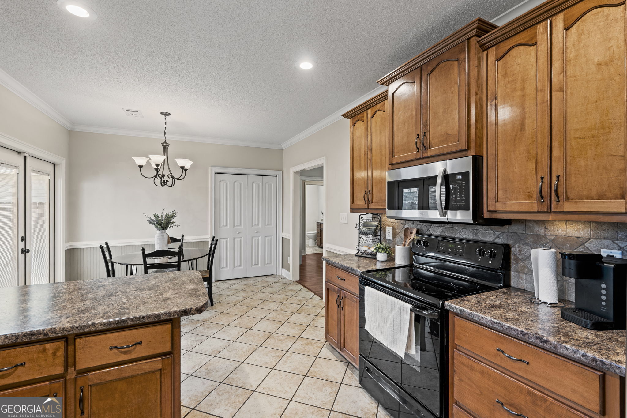 620 Amherst Street Kathleen, GA 31047 - Photo 15 of 31 a kitchen with stainless steel appliances granite countertop a stove a sink a microwave and dining table