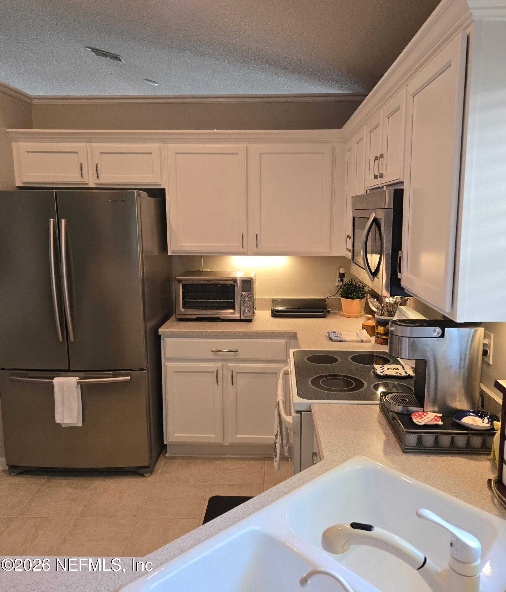 1424 Tintern Lane St. Augustine, FL 32092 - Photo 10 of 32 a kitchen with a refrigerator sink and cabinets