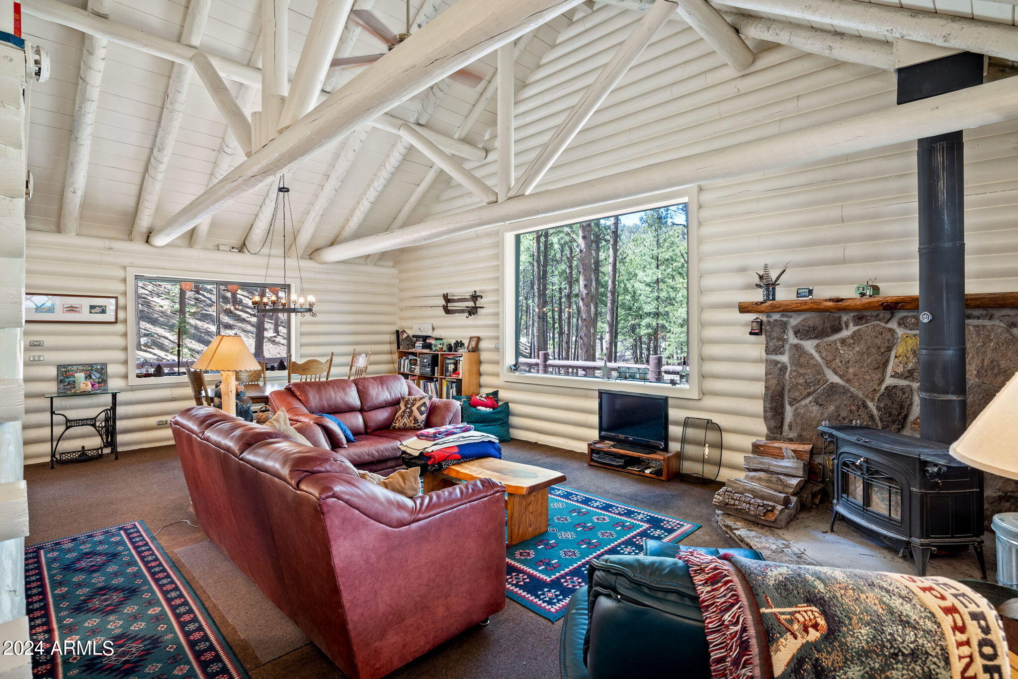 9 County Road Greer, AZ 85927 - Photo 21 of 33 a living room with furniture a fireplace and a floor to ceiling window