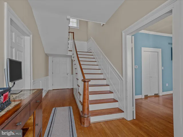 a view of a livingroom with wooden floor and stairs
