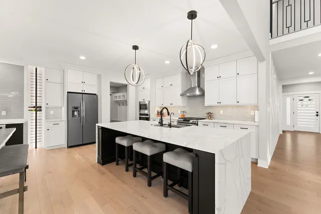 a kitchen with stainless steel appliances a sink stove refrigerator and cabinets