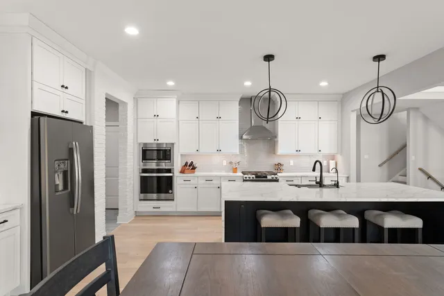 a kitchen with kitchen island granite countertop a stove a refrigerator a sink and a microwave