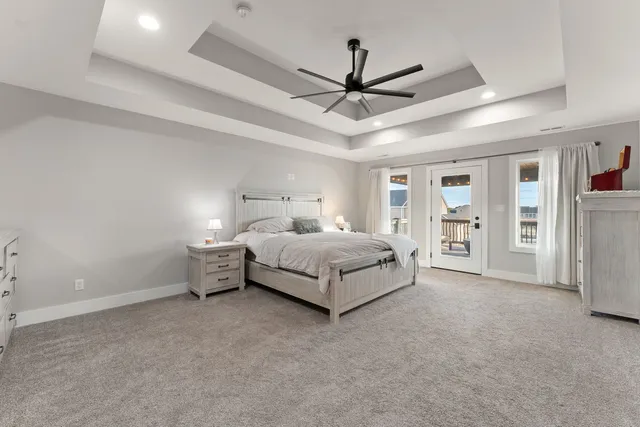 a spacious bedroom with a bed and ceiling fan