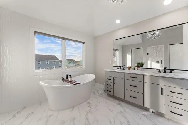 a bathroom with a white tub a vanity a sink and a large mirror