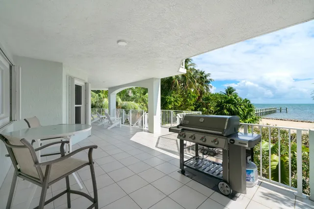 a view of a patio with table and chairs with wooden floor and fence