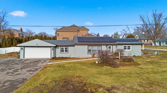 a front view of house with yard and trees in the background