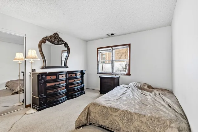 a bedroom with a bed and a large window