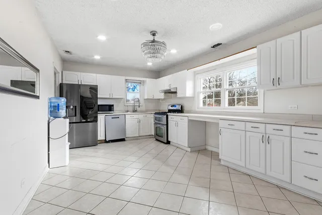 a kitchen with stainless steel appliances granite countertop a refrigerator and a stove