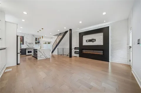 a view of an empty room with wooden floor and stairs