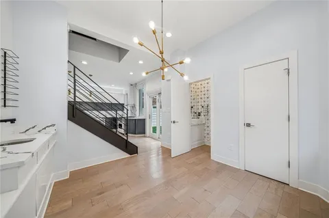 a view of a hallway with stairs and a chandelier