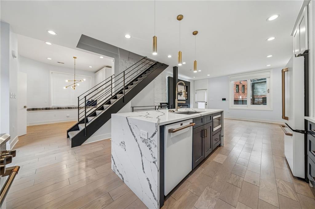 469 42nd Street Pittsburgh, PA 15201 - Photo 6 of 34 a kitchen with stainless steel appliances kitchen island granite countertop a large counter top and stairs