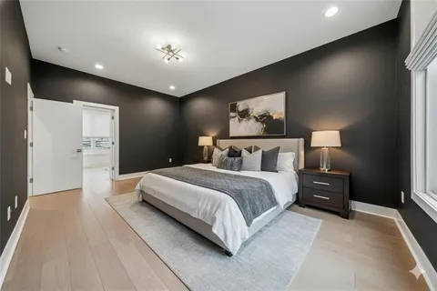 a spacious bedroom with a bed and a night stand