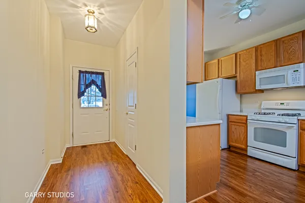 a view of a kitchen with a stove wooden floor a sink and a window