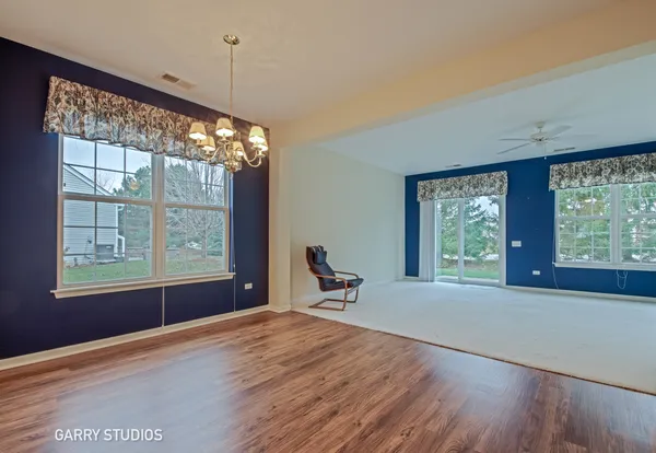 a dining room with wooden floor and windows