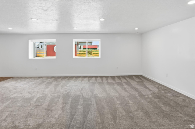 3636 West 910 South Syracuse, UT 84075 - Photo 44 of 70 Spacious room featuring gray carpeting, recessed lighting, white walls, and two egress windows providing natural light