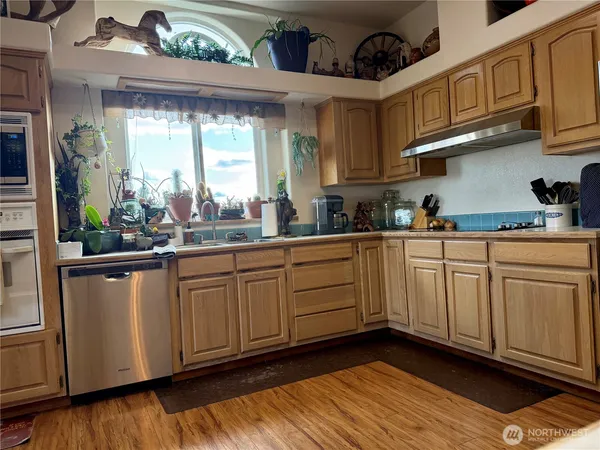 a kitchen with stainless steel appliances granite countertop a sink a stove and cabinets