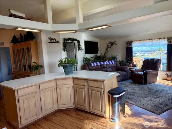 a kitchen with stainless steel appliances kitchen island granite countertop a sink dishwasher and a fireplace