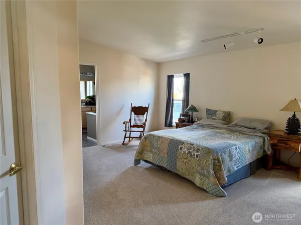 a bedroom with a bed and closet with mirror