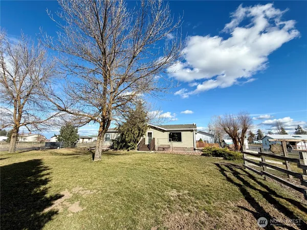 a view of a yard with wooden fence