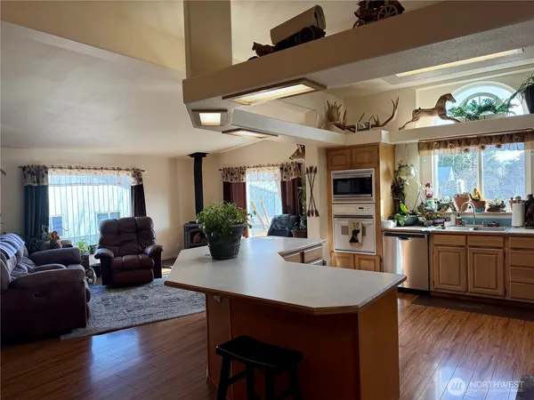 a view of a dining room with furniture a kitchen and chandelier