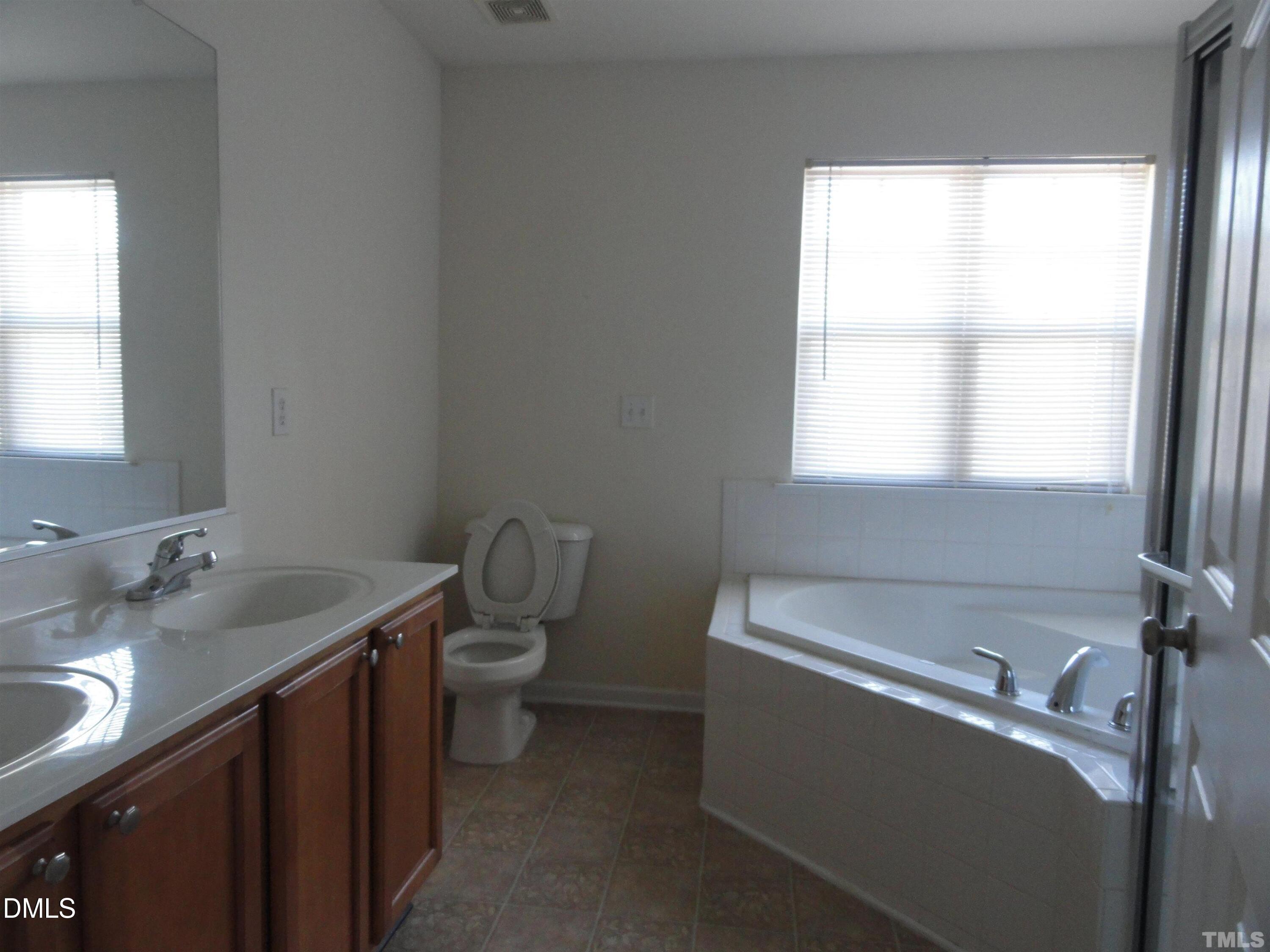 1532 Haywards Heath Lane Apex, NC 27502 - Photo 15 of 26 a bathroom with a granite countertop sink a toilet and a window