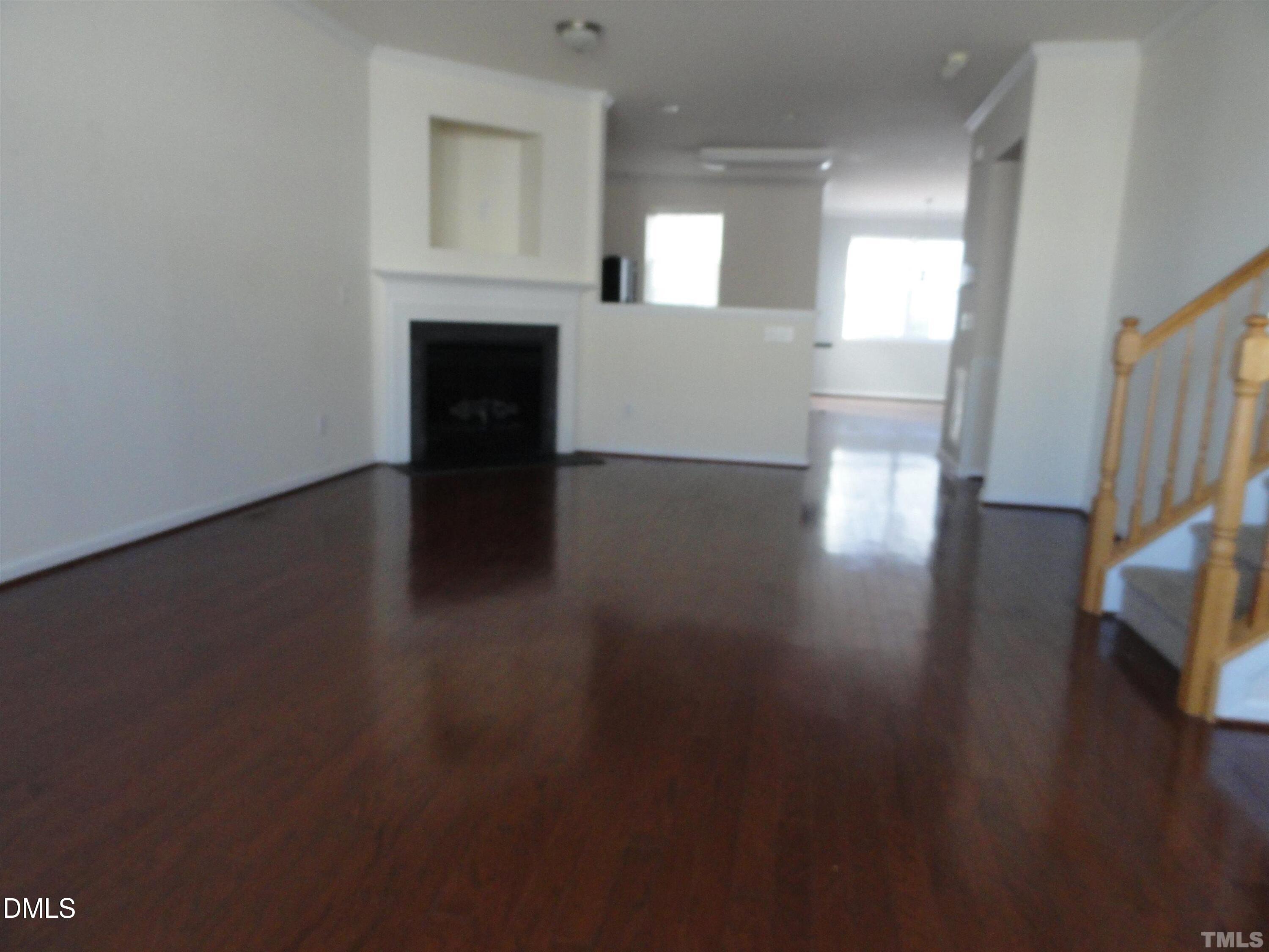 1532 Haywards Heath Lane Apex, NC 27502 - Photo 4 of 26 a view of a livingroom with wooden floor and a fireplace