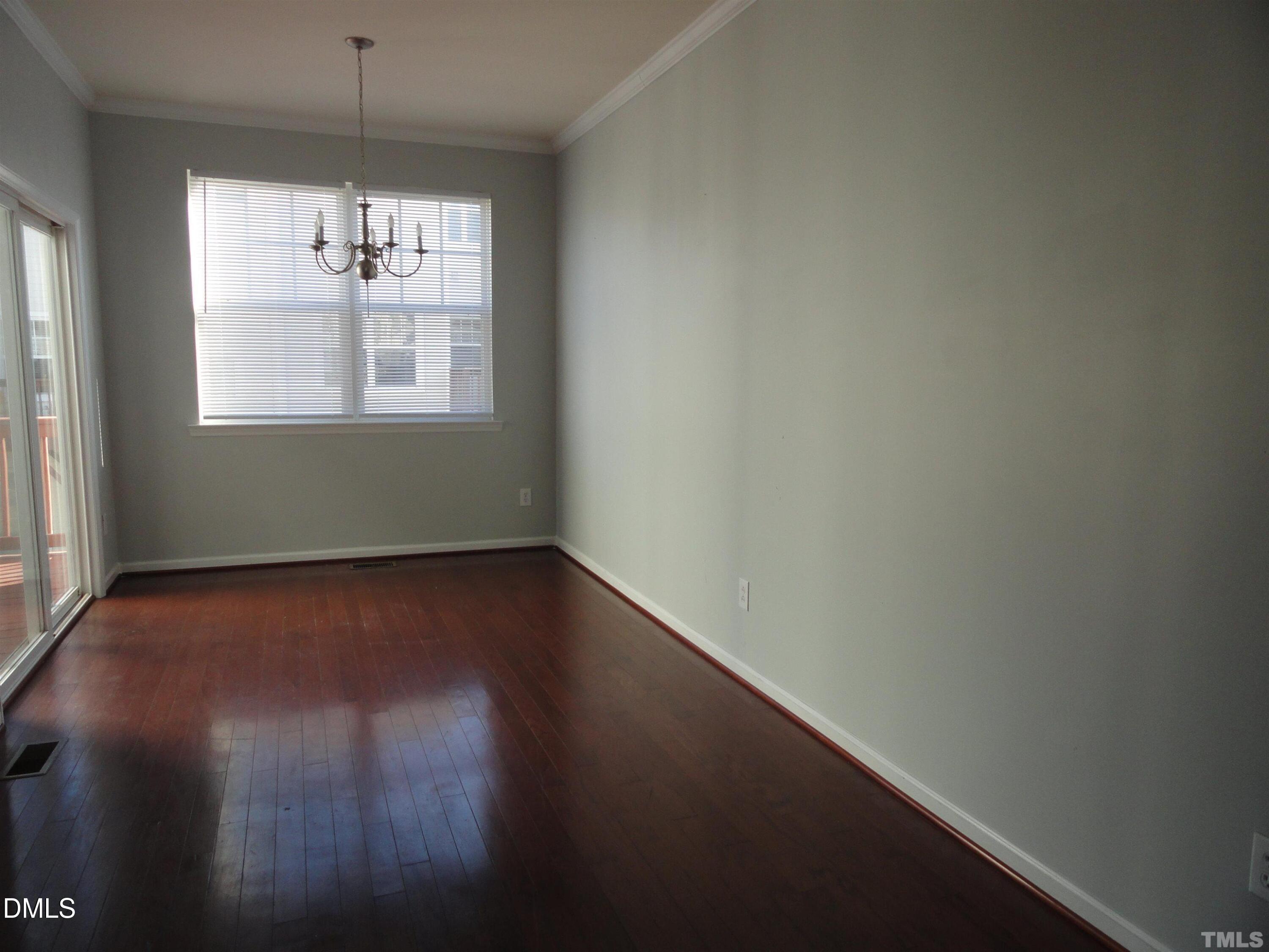 1532 Haywards Heath Lane Apex, NC 27502 - Photo 5 of 26 an empty room with wooden floor and windows