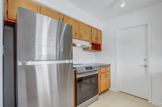 a white refrigerator freezer and a stove sitting inside of a kitchen