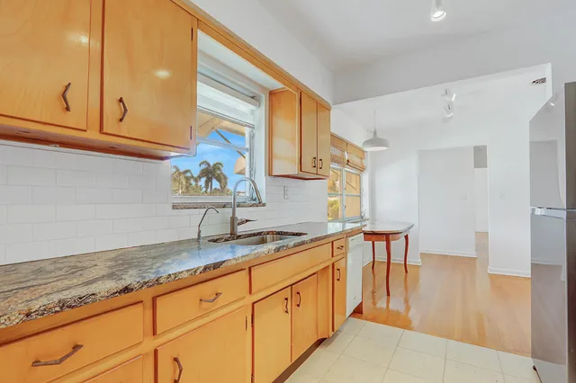 a kitchen with stainless steel appliances granite countertop a sink and a white cabinets
