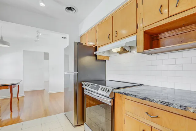 a kitchen with stainless steel appliances granite countertop a refrigerator and a stove