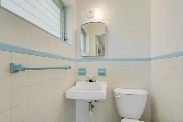 a bathroom with a toilet a sink and mirror