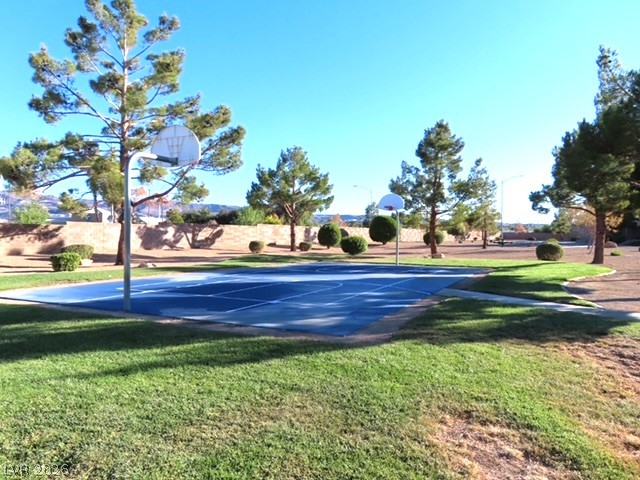 1623 Cave Spring Drive Henderson, NV 89014 - Photo 4 of 16 A vibrant blue basketball court offers outdoor recreation amidst a serene, landscaped setting.
