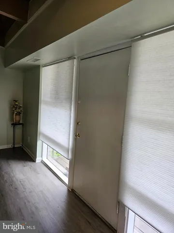 a view of empty room with wooden floor