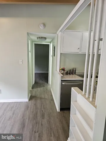 a view of hallway with cabinets and wooden floor